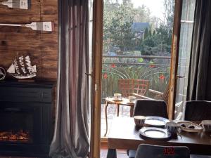 a dining room with a table and a fireplace at Willa Detlafówka in Dębki