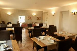 a restaurant with tables and chairs in a room at Hôtel Le Quatorze in Figeac