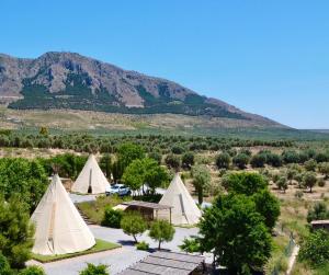 a group of tents with mountains in the background at Boutique Teepee Sleeps 2 with Pool in Zújar
