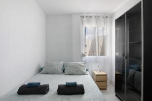a bedroom with a bed with two pillows on it at Medano Beach Home Ocean View in El Médano