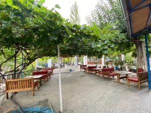 a group of tables and chairs under a tree at Elmas Pansiyon in Karacasu