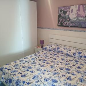 a bedroom with a bed with a blue and white bedspread at Casa Vacanze Maldive del Salento in Torre Pali 