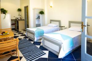 two beds in a room with a checkered floor at White Flat Studios in Dahab