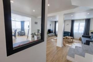 a living room with a blue couch and a mirror at Duplex avec extérieur, 30 min de Paris et Disney in Saint-Maur-des-Fossés