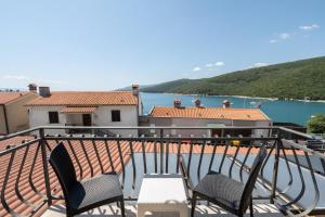 balcón con 2 sillas y vistas al agua en Hotel Nostromo, en Rabac