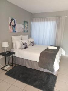 a bedroom with a large white bed with a window at Tsamatiku Villa Guesthouse in Hazyview