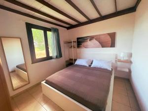 1 dormitorio con 1 cama en una habitación con ventana en Casetta Madre Vita, en Belvedere