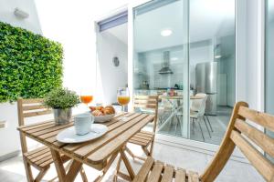 a table with a bowl of fruit and two chairs at Karma Famara 2 25m del mar in Famara