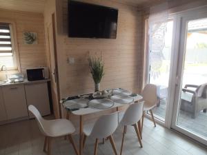 a kitchen and dining room with a table and chairs at Domki letniskowe- Magnoliowa przystań in Firlej +6 photos