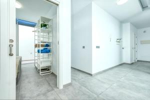 a hallway with white walls and tile floors at Karma Famara 2 25m del mar in Famara