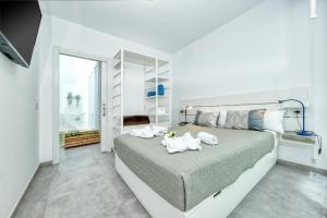 Un dormitorio blanco con una cama grande con toallas. en Karma Famara 2 25m del mar en Famara