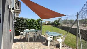 un patio con mesa, sillas y sombrilla en Casa las Nubes, en Lumpiaque