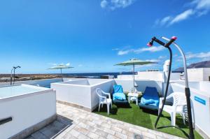 a microphone on a roof with chairs and umbrella at Karma Famara 2 25m del mar in Famara