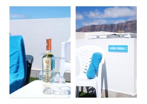 a table with a bottle of wine and a chair with a blue sock at Karma Famara 2 25m del mar in Famara