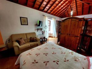 1 dormitorio con 1 cama y 1 sofá en Las Toscas, en Mazo