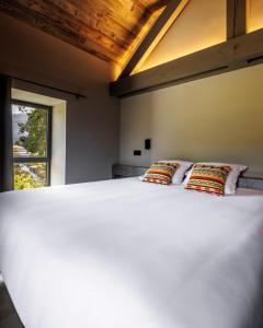 a bedroom with a large white bed with two pillows at Pyrénées Prestige - Villas d'exceptions et hébergements insolites in Argelès-Gazost