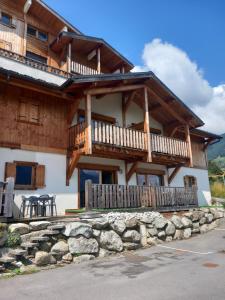 a large wooden house with a balcony and a table at Les Hauts de Sallanches in Sallanches