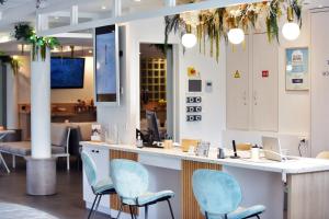 un bar avec des chaises bleues dans un cabinet dentaire dans l'établissement Hôtel Kyriad La Rochelle Centre Ville, à La Rochelle