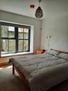 ein Schlafzimmer mit einem Bett und einem großen Fenster in der Unterkunft Corradiller Quay, Lisnaskea, Fermanagh in Lisnaskea