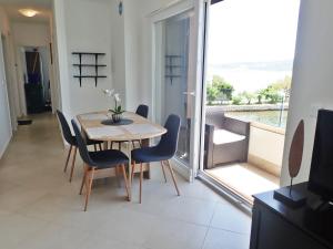 a dining room with a table and chairs and a balcony at Plava Laguna with beautiful seaview in Seline +17 photos