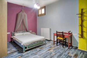 a bedroom with a bed and a table and a desk at Maria's House in Zagora