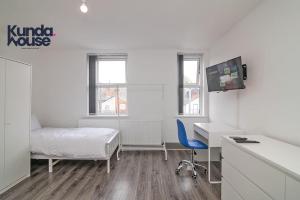 a bedroom with a bed and a desk and a tv at Kunda House Old Grange in Birmingham