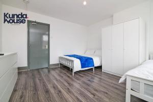 a bedroom with a bed and a walk in shower at Kunda House Old Grange in Birmingham