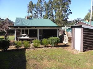 a small house with a green roof and a yard at Splendid Wren Cottage in Deeside