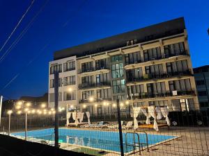 a building with a swimming pool in front of a building at Seaside Inn & Suites in Costinesti
