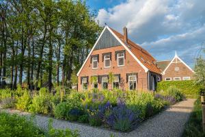 a brick house with a garden in front of it at Hofparken Wiltershaar - groepsaccommodatie met privé wellness in Kotten