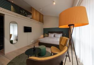 una camera d'albergo con letto, tavolo e lampada di Hotel Schweizerhof Lenzerheide a Lenzerheide
