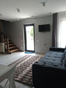 a living room with a couch and a tv at На березі річки in Synevyr