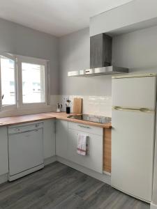 a kitchen with white cabinets and a white refrigerator at Apartamento playa sada in Sada
