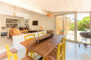 Una sala de estar con una mesa y sillas de madera. en Tranquility, en Cape St. Francis