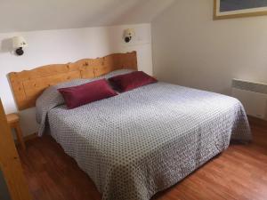 a bedroom with a bed with a red pillow on it at Chalet Mitoyen 3 Pièces 6 Pers. - Résidence Le Hameau du Puy - Piscine Chauffée, Proche Pistes - FR-1-504-642 in Superdevoluy