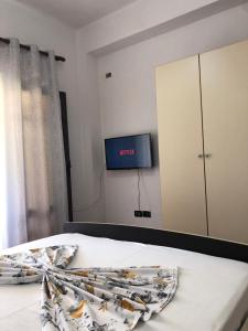 a bedroom with a bed and a tv on a wall at Villa Edi in Vlorë