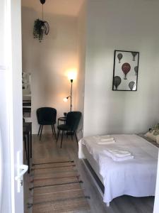 a bedroom with a bed and a table and chairs at Near City park only 5 minutes walk , where you can find the world famous Szechenyi thermal bath spa, Capital Circus , Museums The apartment is modern and newly renovated ,in a quiet and peaceful green Oasis with AC ,smart TV, high speed internet in Budapest +67 photos