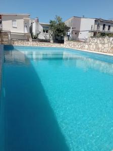 una gran piscina de agua azul frente a los edificios en Villa Mona Liza en Dobra Voda