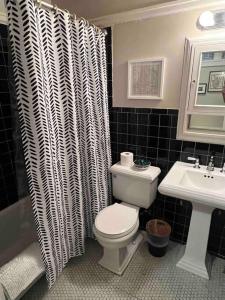 a black and white bathroom with a toilet and a sink at Cozy Bohemian Midtown Studio at Minglewood Hall in Memphis