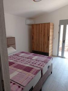 1 dormitorio con 1 cama y puerta de madera en Villa Mona Liza en Dobra Voda