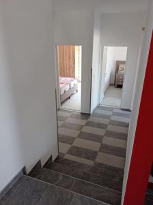 a hallway with a checkerboard floor and a bedroom at Villa Mona Liza in Dobra Voda