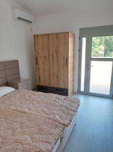 a bedroom with a large bed and a sliding door at Villa Mona Liza in Dobra Voda