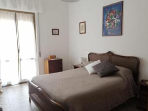a bedroom with a bed and a large window at La casa di GB in Pieve di Teco