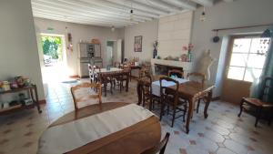 uma sala de jantar com mesas e cadeiras e uma lareira em Le Relais des Fontaines em Nouans-les-Fontaines