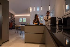 un hombre y una mujer de pie en una cocina en Villa Golden Root Real Estate, en San Teodoro