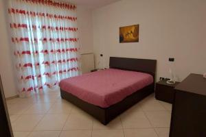 een slaapkamer met een bed met een rode sprei bij Casa vacanze Margherita in Barletta