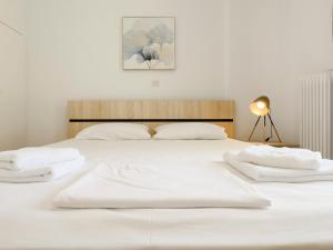 un letto bianco con due asciugamani bianchi di Metamorfoseos Spacious 120sqm apt in Alimos ad Atene
