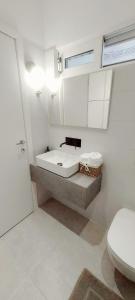 a bathroom with a sink and a toilet at Al mare in Sounio +16 photos