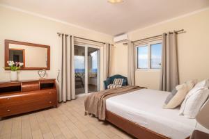 - une chambre avec un lit, une commode et un miroir dans l'établissement Sea Breeze Villa, à Tsilivi
