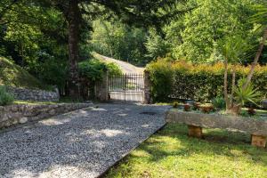 un jardín con una puerta y un banco de piedra en Villa "Il Prado" Piscina&Natura, en Camaiore